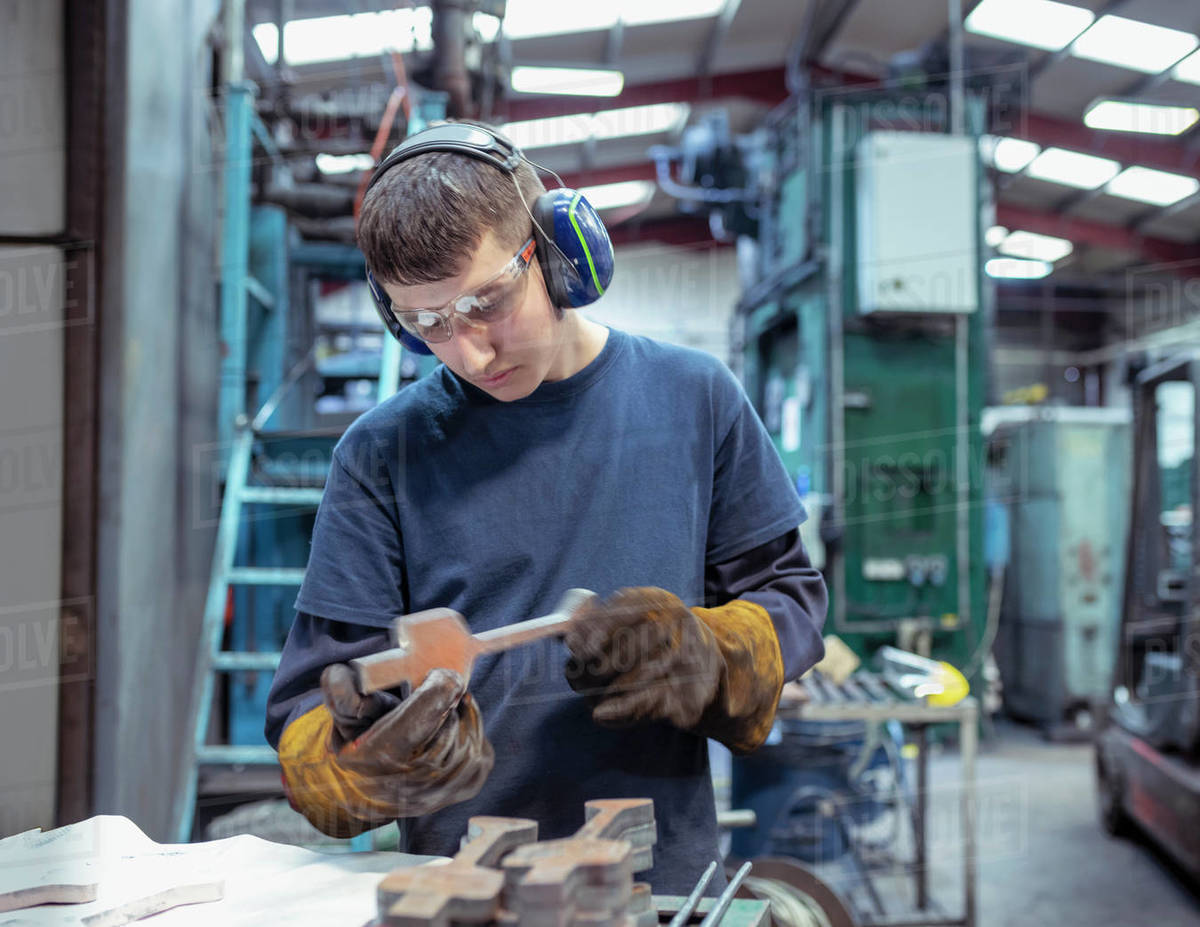 Apprentice engineer inspecting titanium blank before in