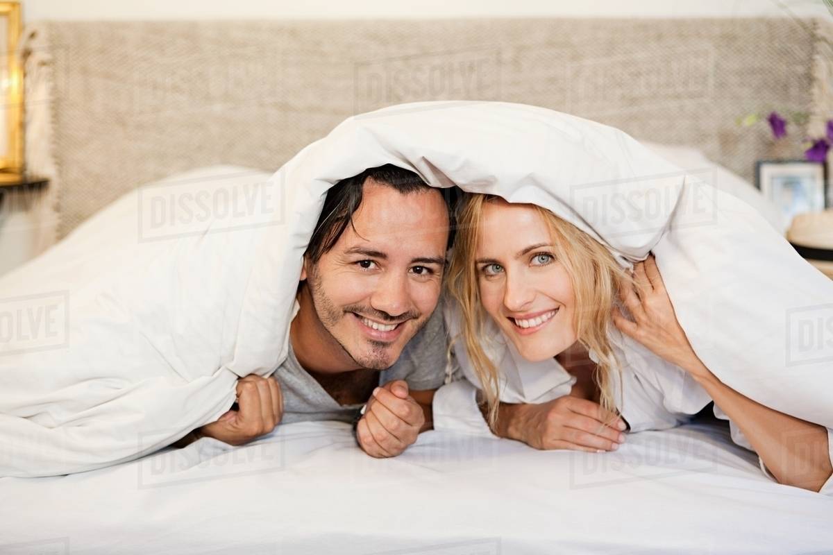 Couple under duvet Stock Photo Dissolve