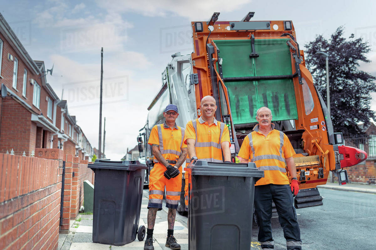 Portrait of refuse collectors with bins and refuse truck Stock Photo