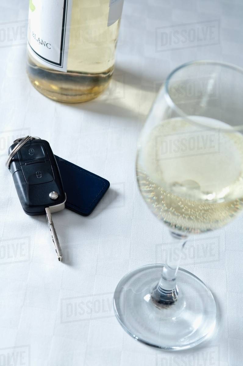 Car keys and a glass of white wine Stock Photo Dissolve