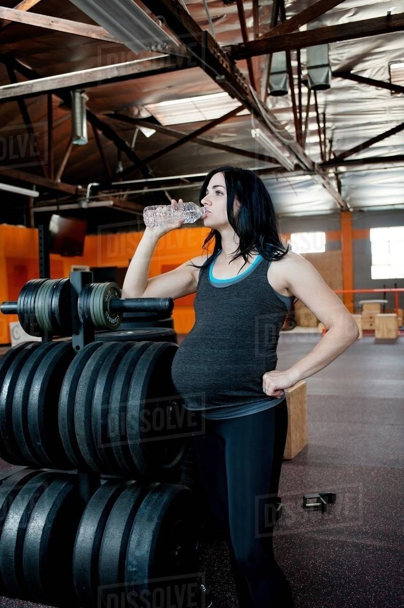 Pregnant young woman drinking mineral water Stock Photo Dissolve