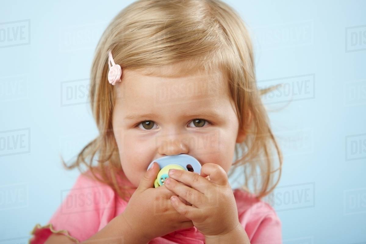Girl with pacifier in mouth Stock Photo Dissolve
