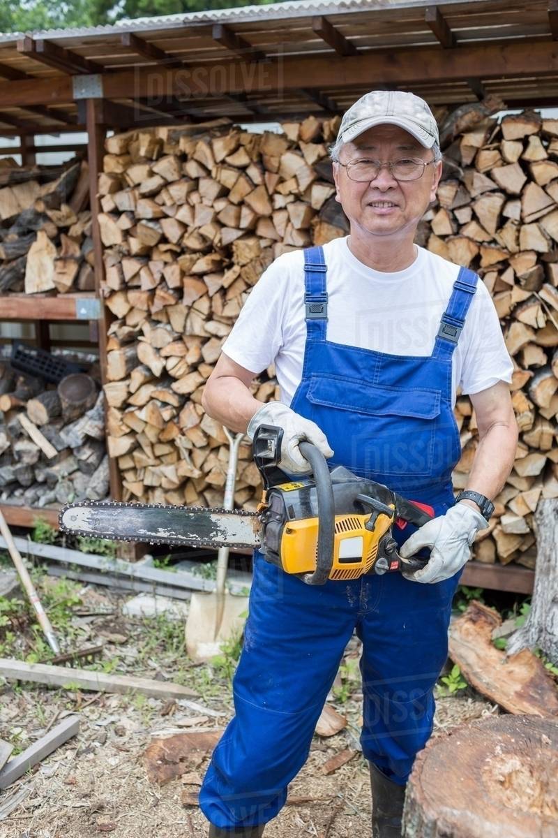 Man carrying chainsaw Stock Photo Dissolve