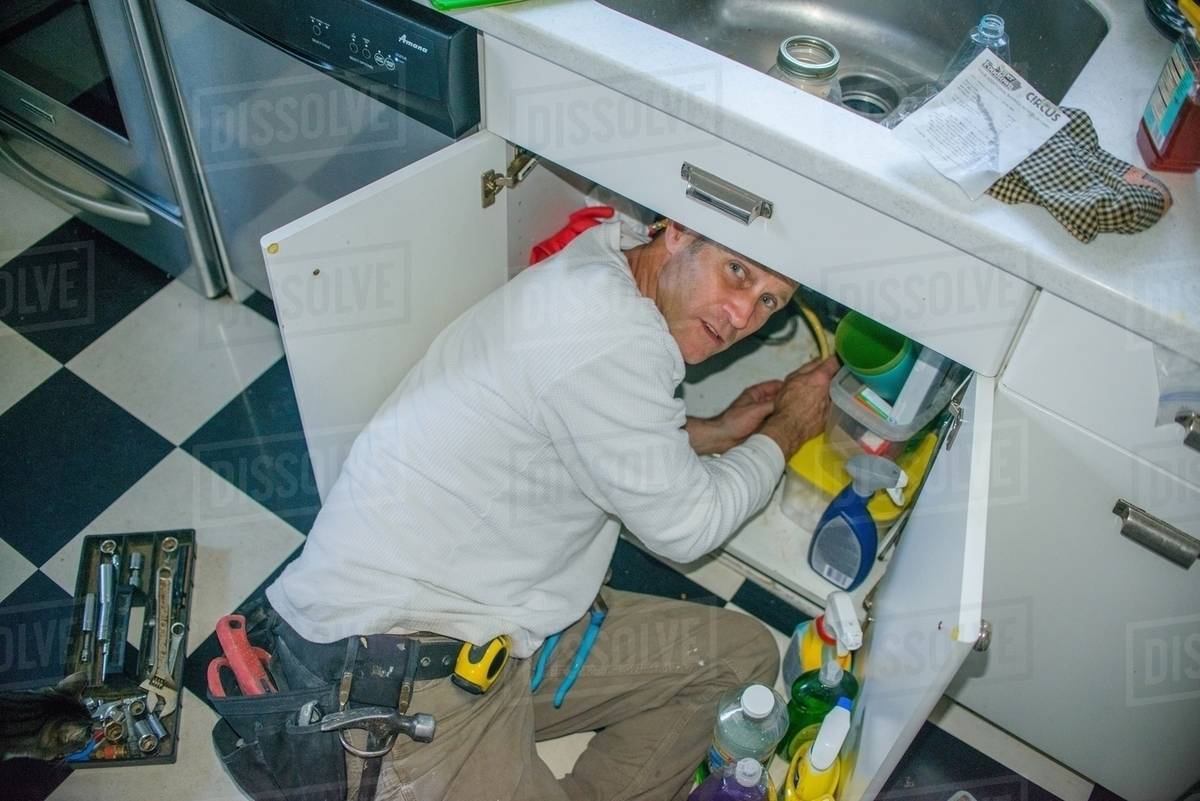 Handyman Fixing Kitchen Sink Pipe Stock Photo