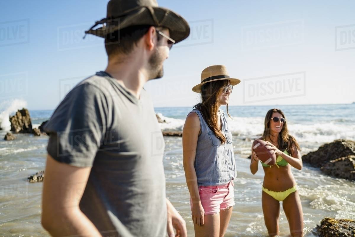 Three Friends Playing American Football In Sea At Newport Three Friends Playing American Football In Sea At Newport Beach California Usa