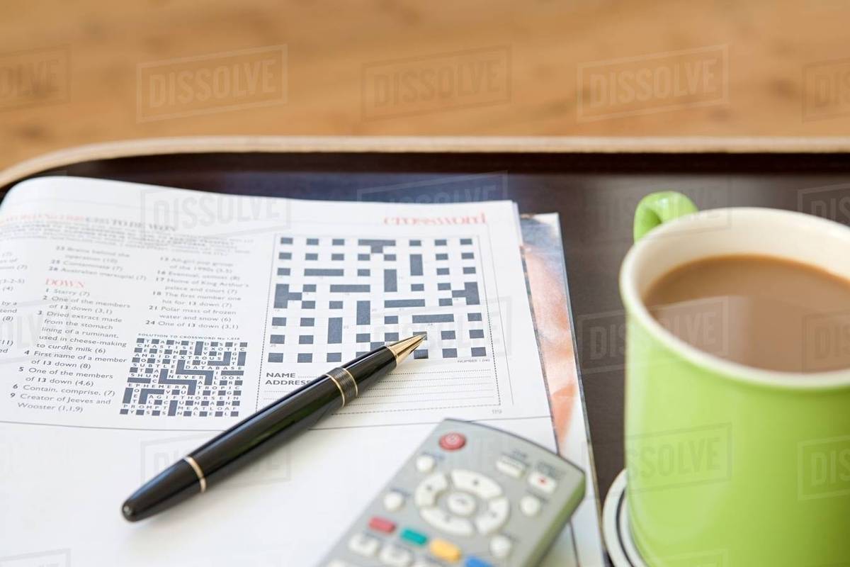 A crossword pen and cup of tea Stock Photo Dissolve
