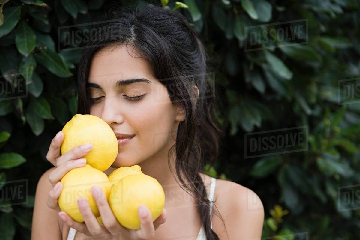Woman smelling lemons Stock Photo Dissolve