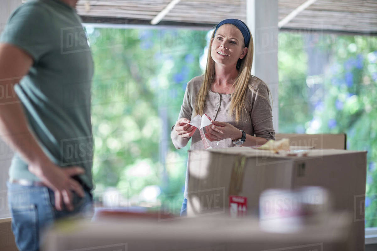 Moving house couple marking boxes with fragile stickers Stock Photo