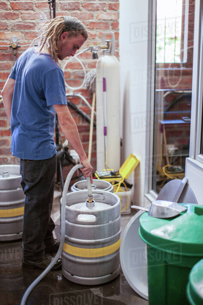 Man cleaning beer kegs in microbrewery Stock Photo Dissolve