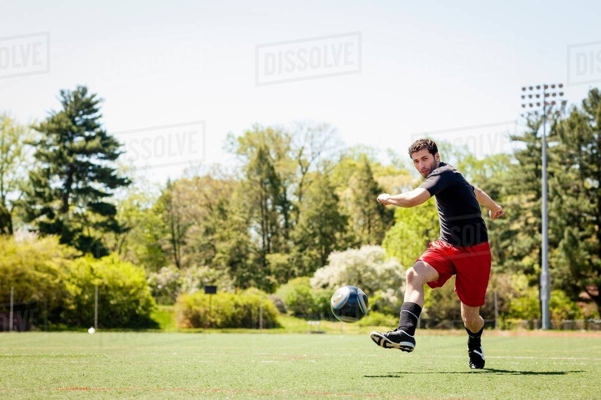 Soccer player running and kicking ball - Royalty-free Stock Photo ...