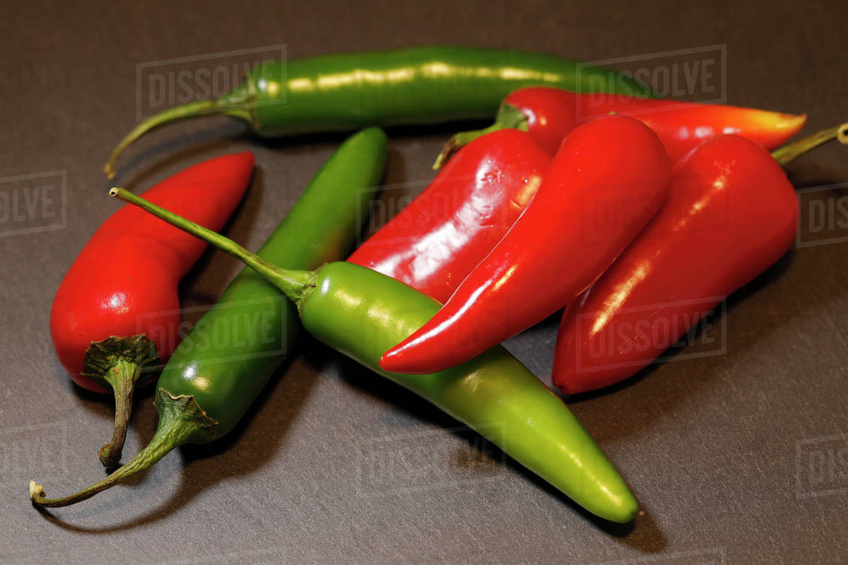 A close up of spicy red and green chili peppers in a studio setting ...