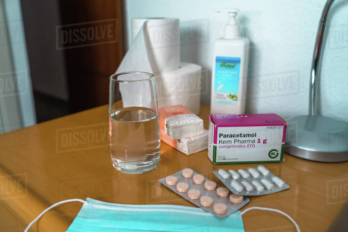 Paracetamol pills, glass of water, Sanitizing Gel, tissues and medical