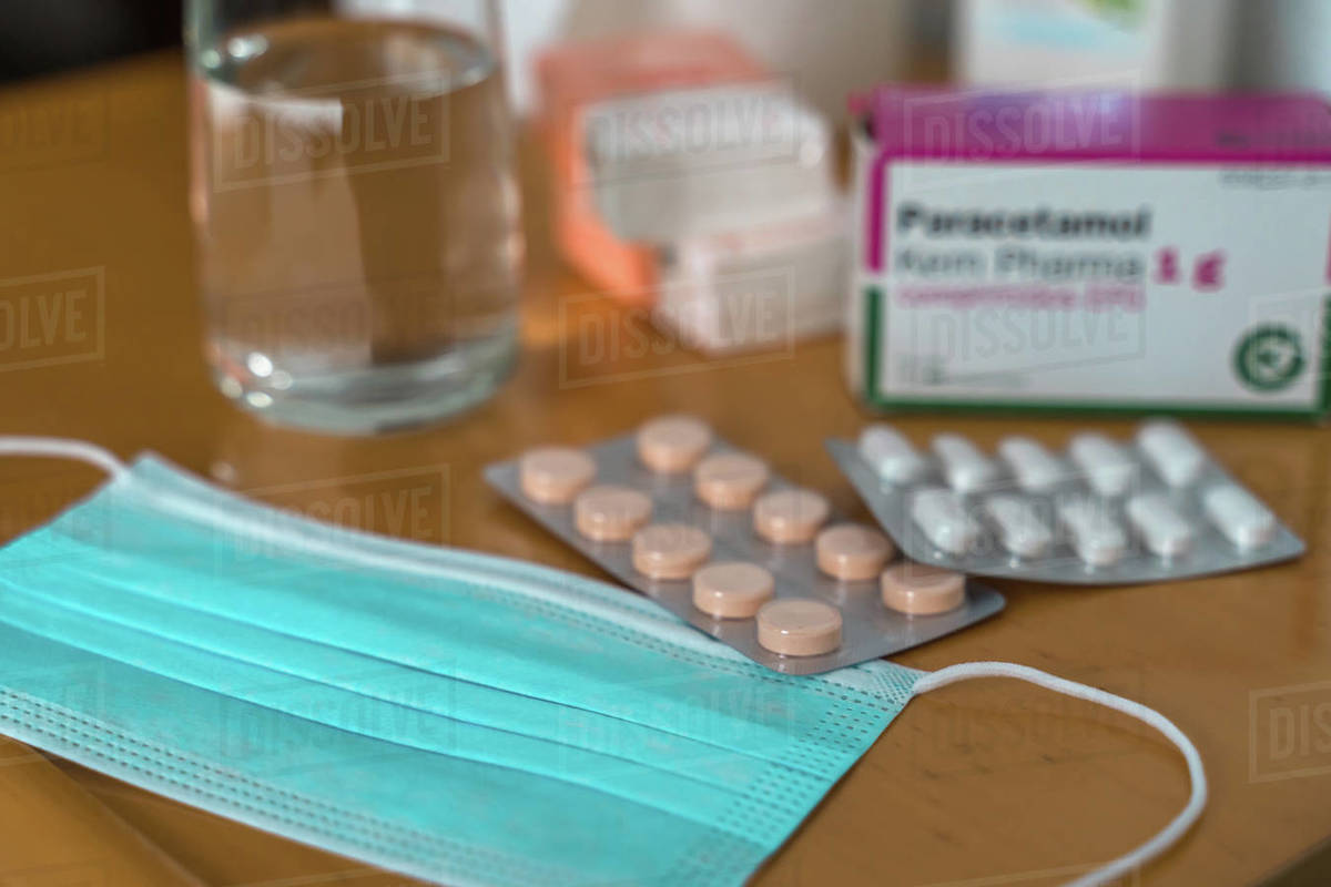 Paracetamol pills, glass of water, Sanitizing Gel, tissues and medical