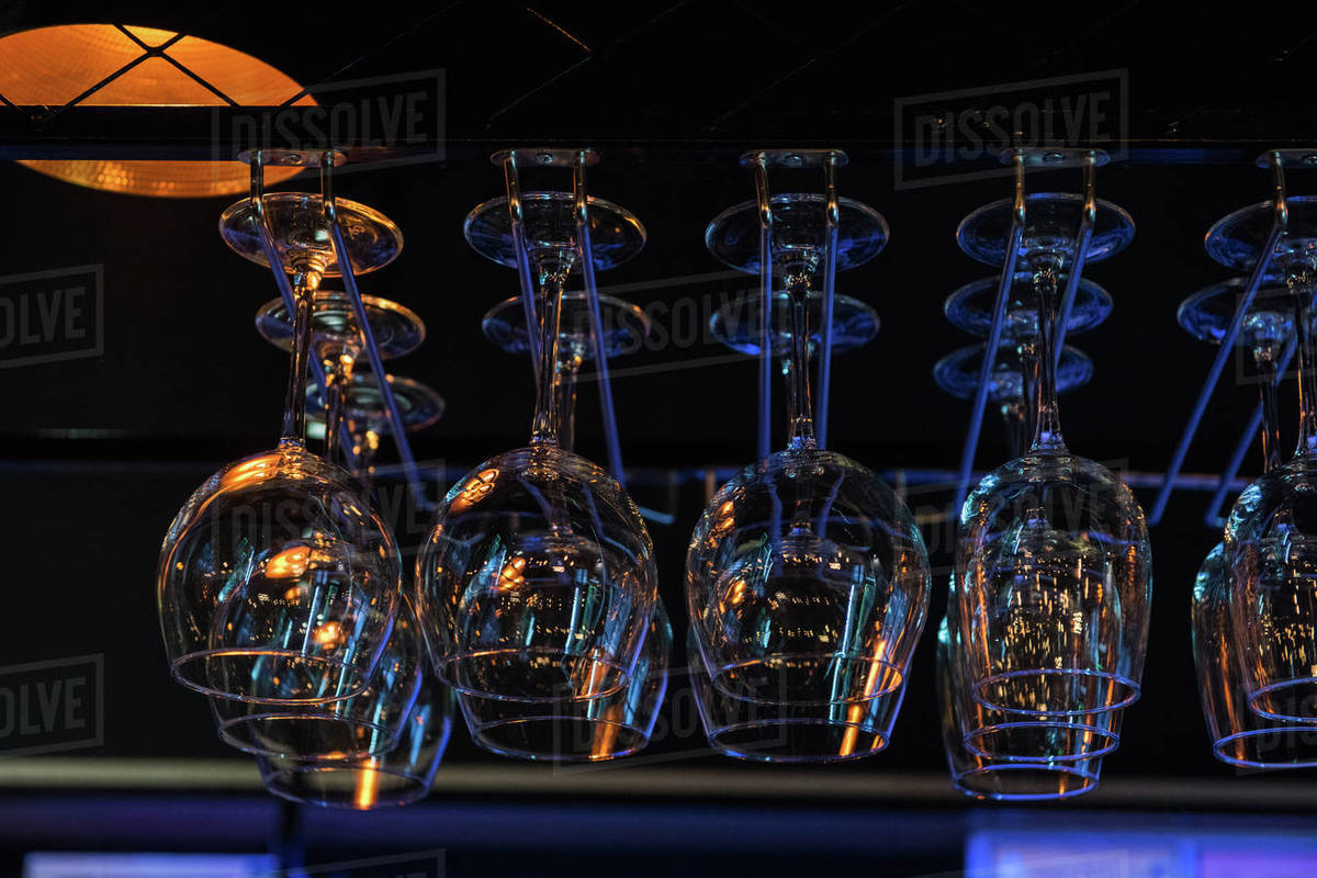 Empty clean glasses for wine above a bar rack Stock Photo Dissolve