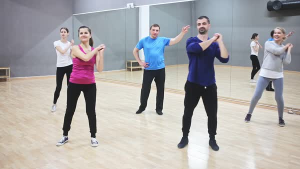 Cheerful people practicing vigorous lindy hop movements in dance class ...
