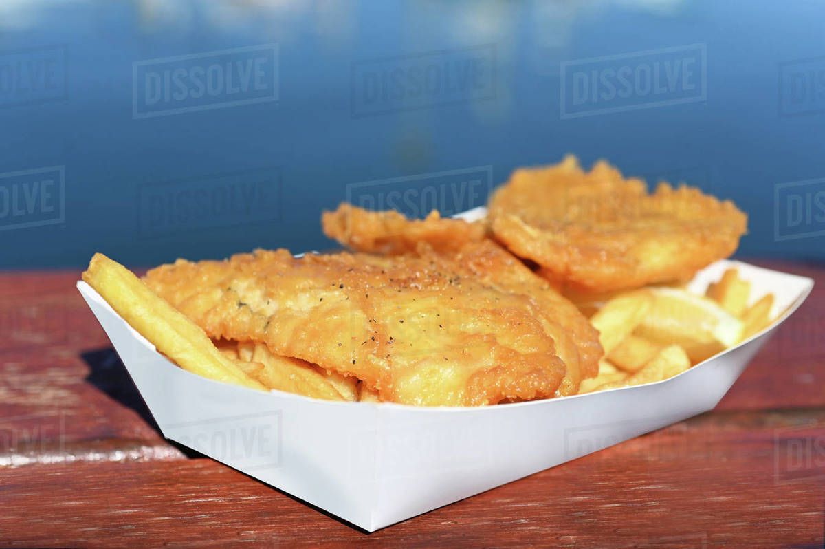 Fresh Fish and Chips served in a cardboard tray on a waterfront