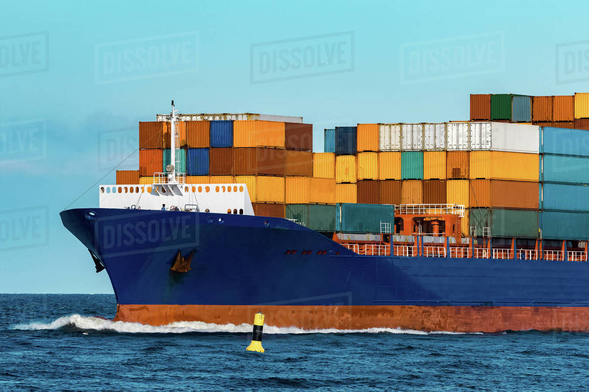 Blue container ship in travel. Logistics and freight industry Stock Photo Dissolve