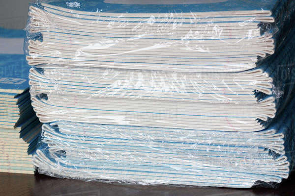 Stack of Notebooks. A pack of blue school notebooks in cellophane on ...