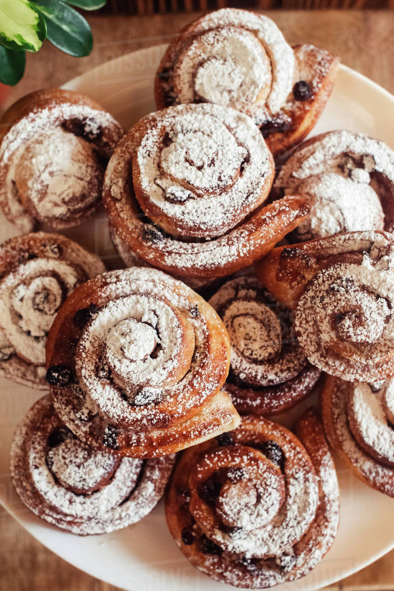 Puff pastry cakes curl with powdered sugar on top. A closeup of a