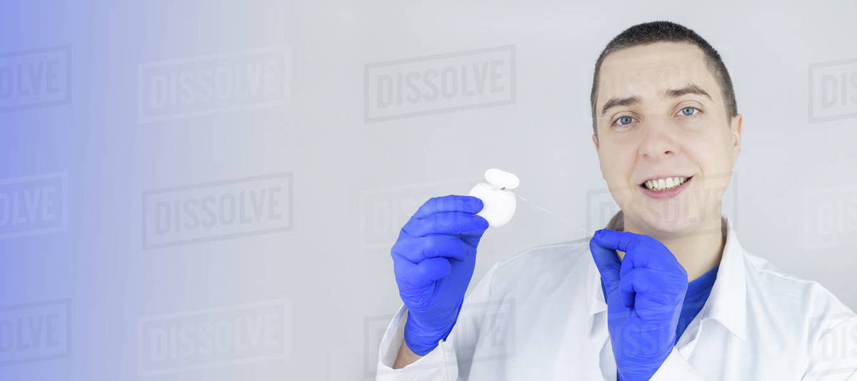 Dental floss close up. Dentist shows how to use the thread correctly