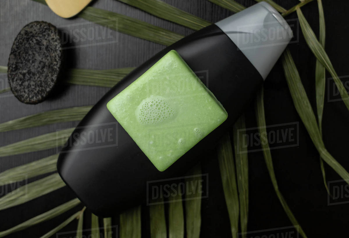 Solid hair shampoo. Composition of golden curls, soap suds, solid shampoo and comb. The concept