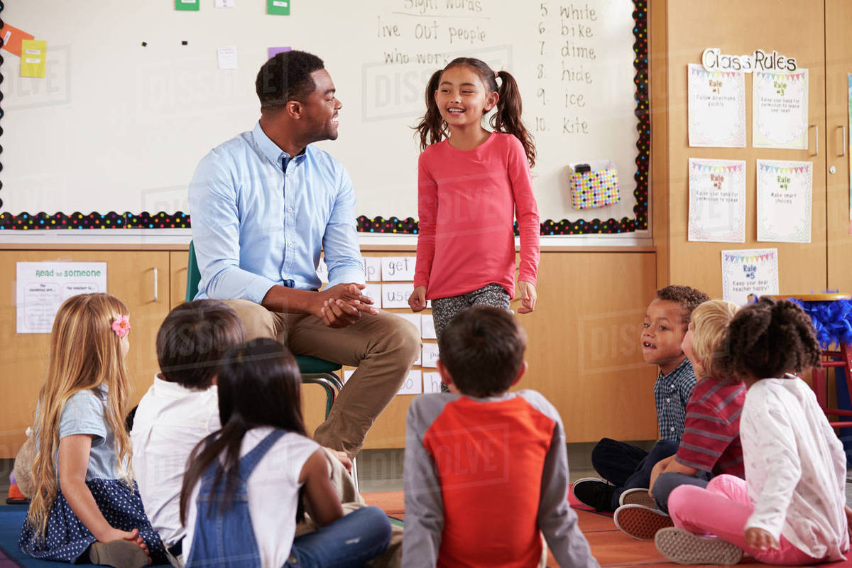 Schoolgirl At The Front Of Elementary Class With Teacher Schoolgirl At The Front Of Elementary Class With Teacher