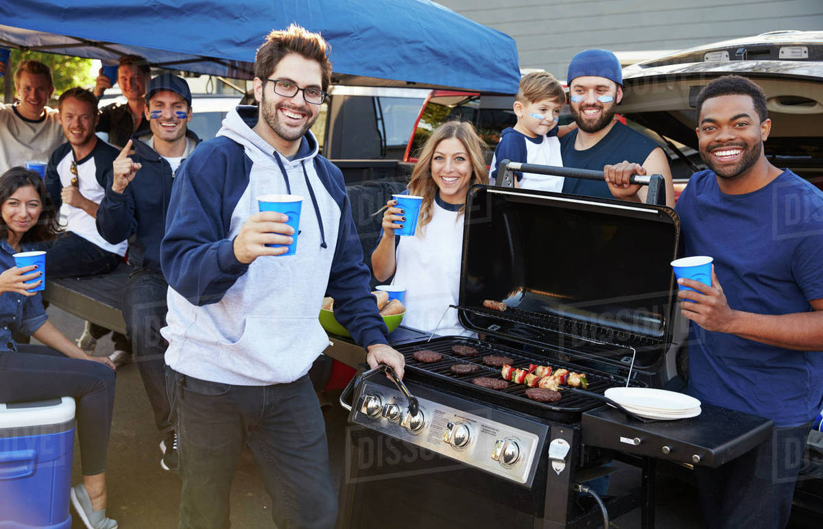 Group Of Sports Fans Tailgating In Stadium Car Park Stock Photo