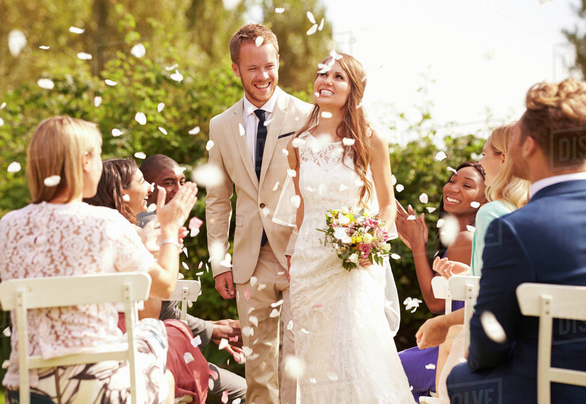 Guests Throwing Confetti Over Bride And Groom At Wedding Royalty-free stock photo