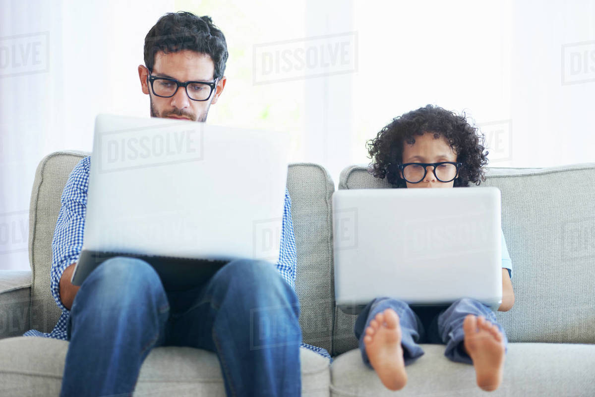Father, child and laptop working on sofa in living room together with ...