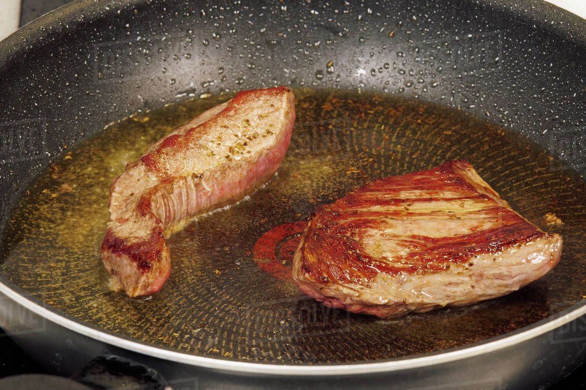 Top sirloin marbled American beef steak on a pan. Highangle focus on
