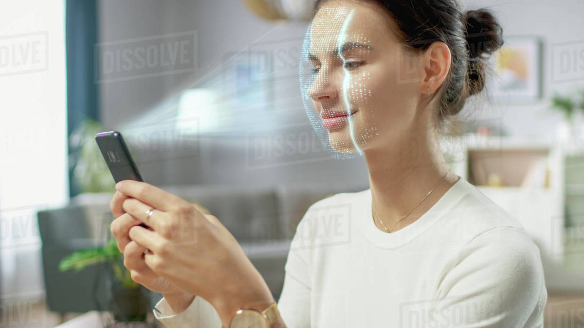 Young female identified by biometric facial recognition scanning process from her smartphone. Futuristic concept: projector identifies individual by illuminating face by dots and scanning with laser Royalty-free stock photo