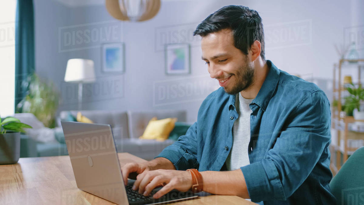 Portrait of Handsome Young Man Using Laptop Computer at Home, Watching ...