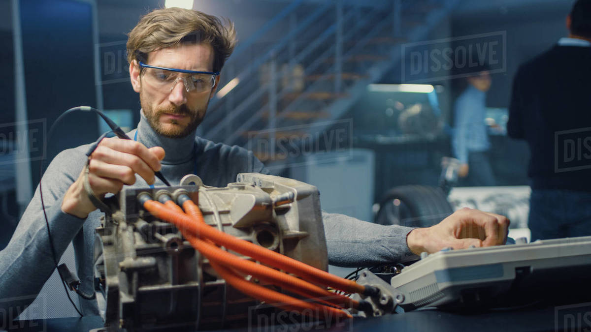 Professional Automotive Engineer in Glasses with a Computer and