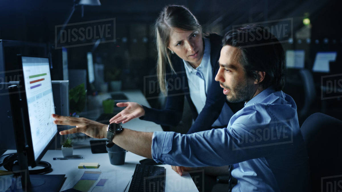 Confident Businessman Uses Desktop Computer, His Female Manager