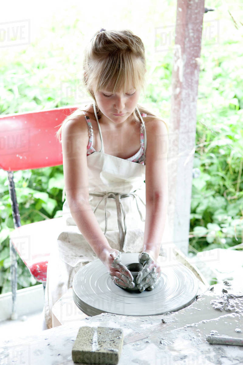 Girl making clay pot Stock Photo Dissolve