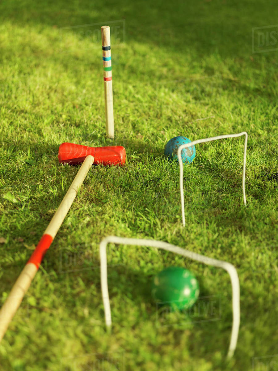 Croquet mallets and balls on lawn Stock Photo Dissolve