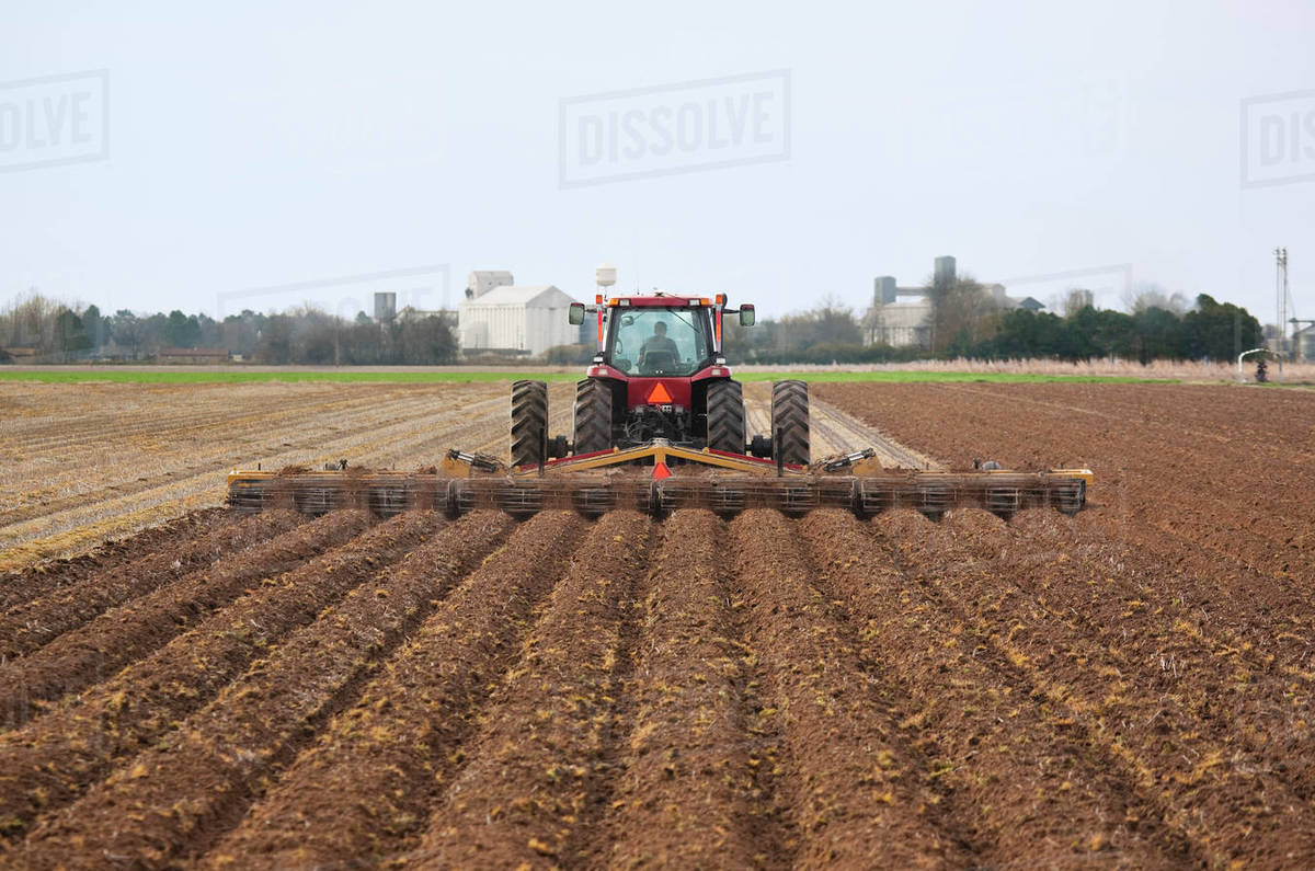 Agriculture A Case IH tractor and field implement finish soil