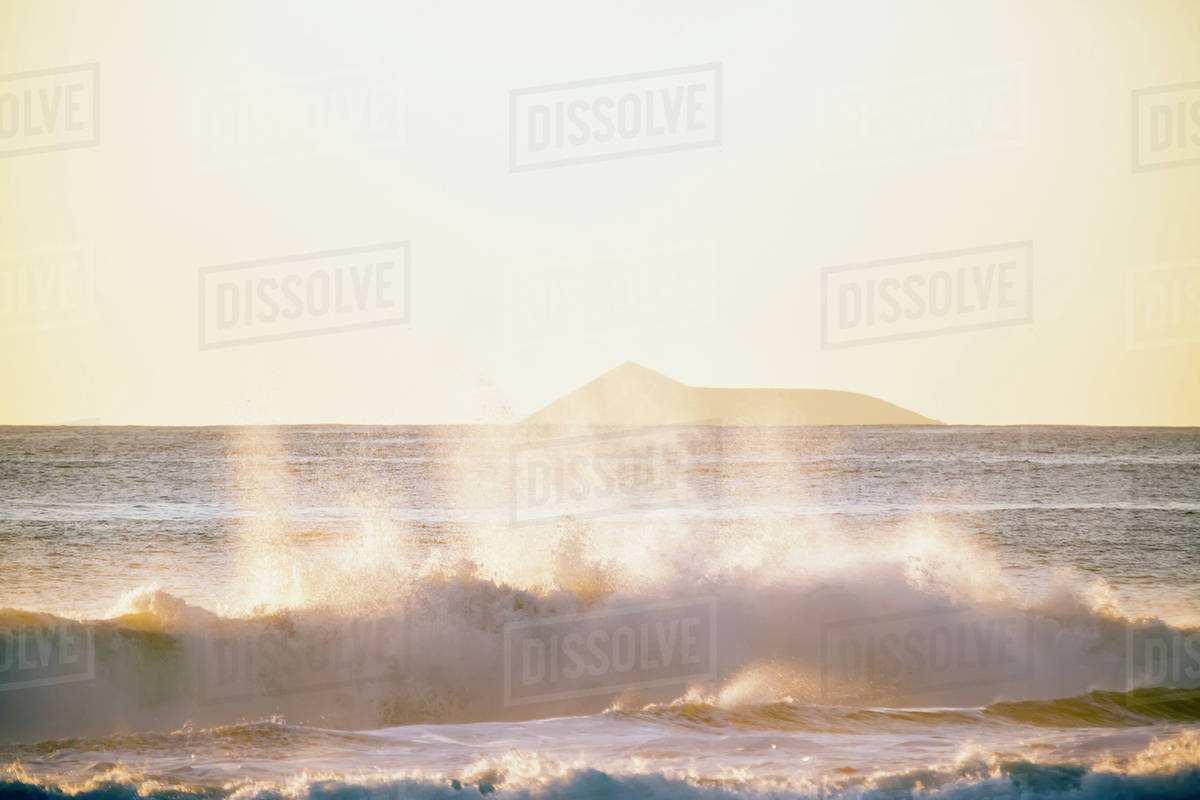Golden surf visible from Barking Sands Beach in Kekaha with Lehua