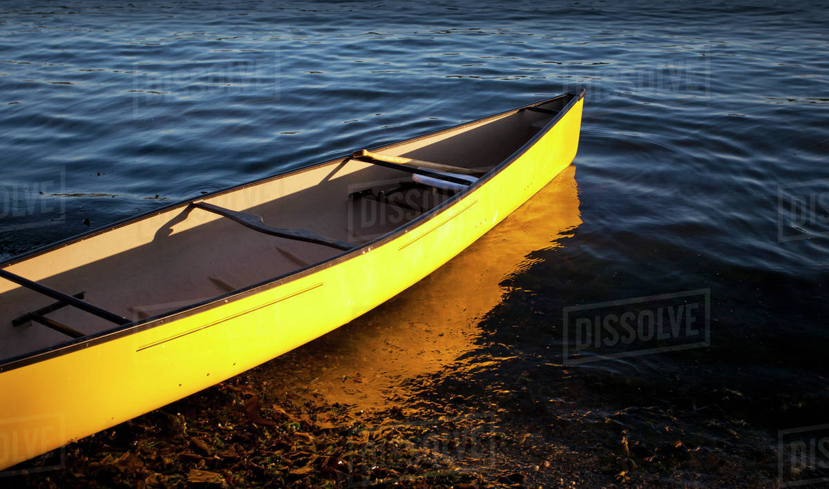 Yellow canoe in the shallow water at the water's edge; Vancouver