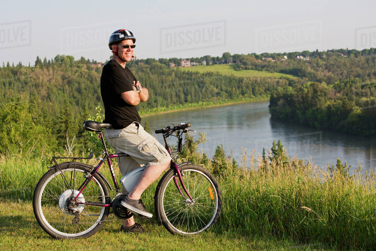 Man riding his electric bicycle with Edmonton city skyline in the