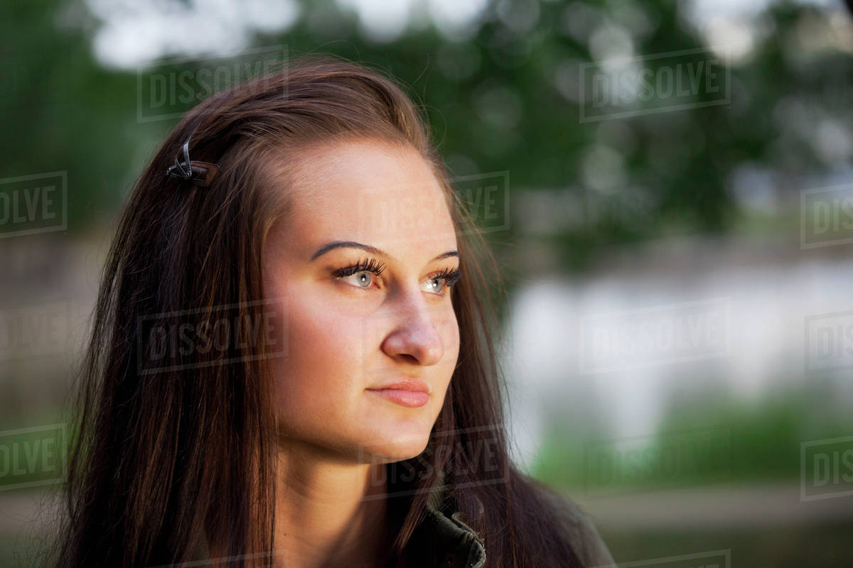 Portrait of a beautiful young woman in a park at twilight; St. Albert, Alberta, Canada Stock