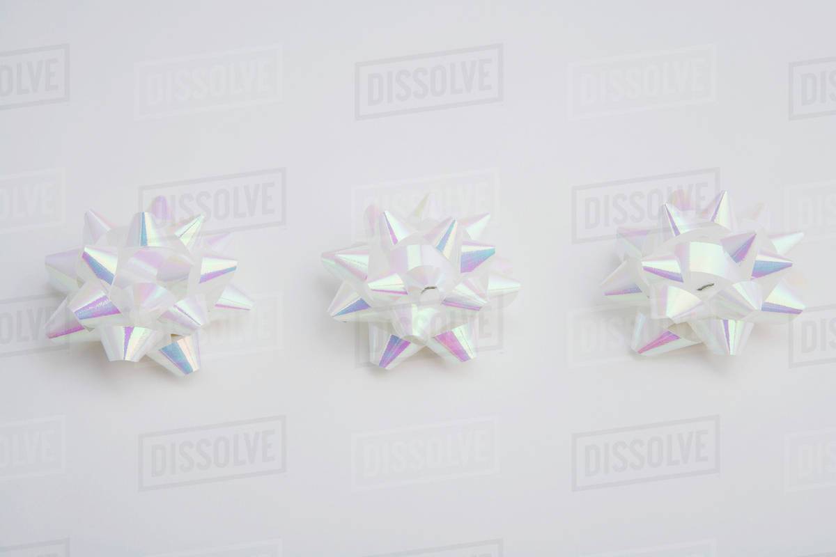 Three White Christmas Gift Bows In Row On White Background Studio