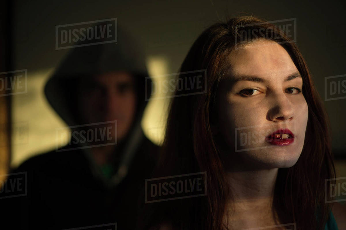 Man stands behind a vampire-like woman with blood in her mouth; Lincoln