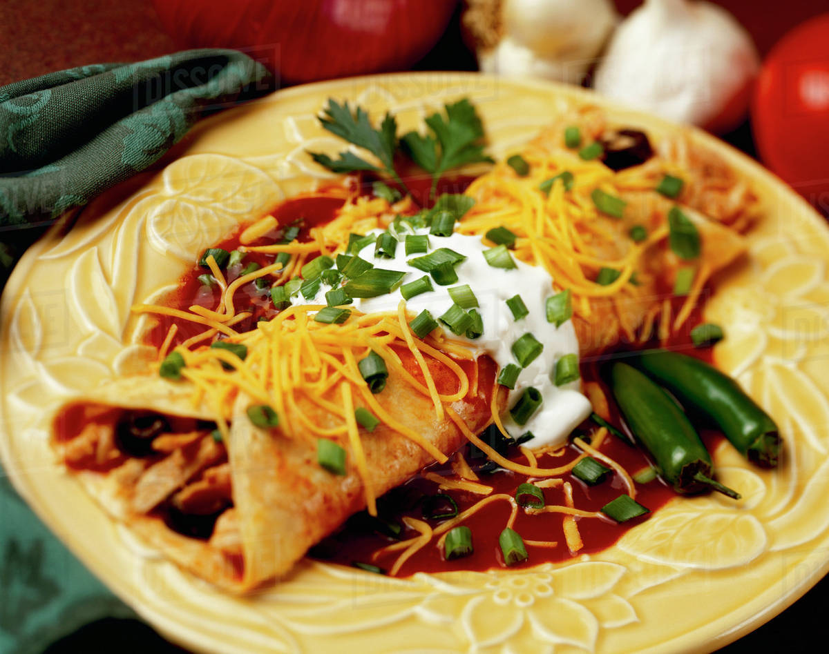 Food Chicken and Cheese Enchilada garnished with chopped green onions