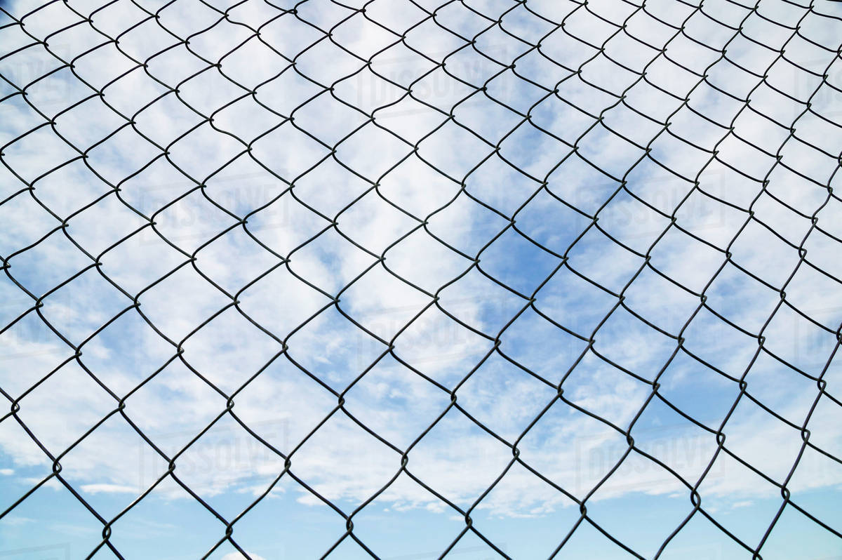 Chain Link Fence And Blue Sky With Cloud; Canada - Royalty-free Stock Photo  | Dissolve