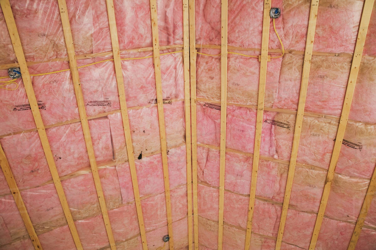 Unfinished Ceiling With Exposed Pink Fiberglass Insulation In A