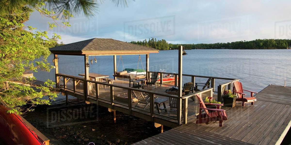 Patio furniture on a wooden dock on a lake;Lake of the woods ontario