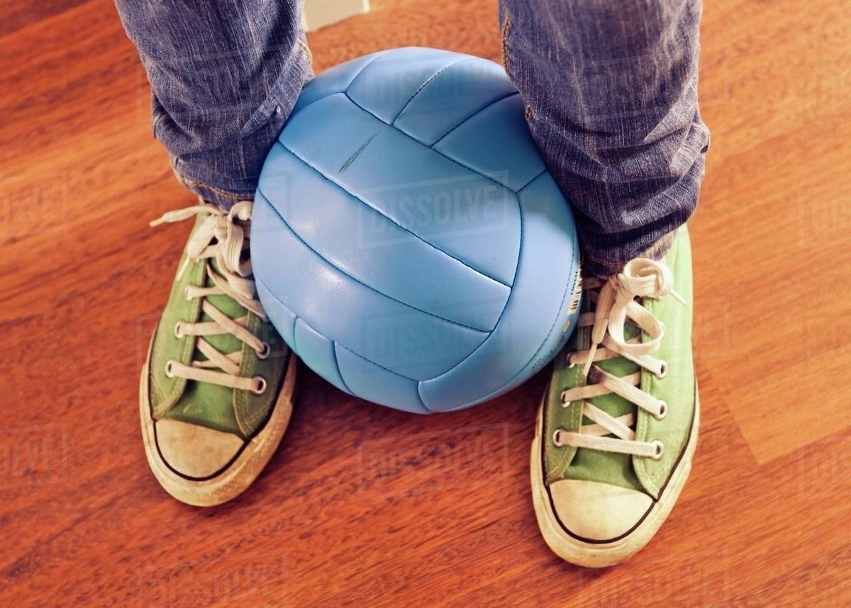 A Blue Volleyball Held Between Two Feet Stock Photo Dissolve