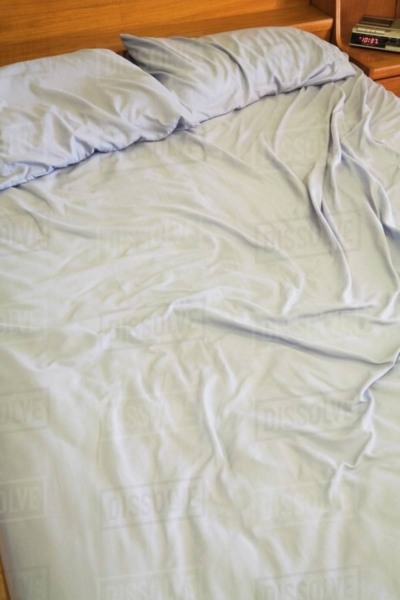 Queen Size Bed With Rumpled Sheets - Stock Photo - Dissolve