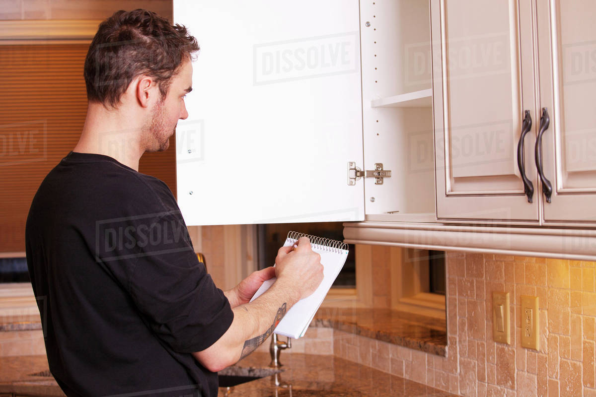 Carpenter Measuring And Installing New Kitchen Stock Photo Dissolve